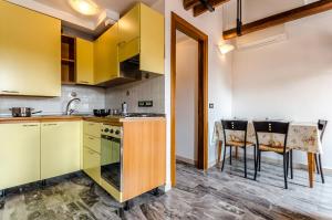 ヴェネツィアにあるVenice Apartmentsのキッチン(黄色のキャビネット、テーブル、椅子付)