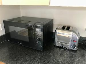 a microwave sitting on a counter next to a toaster oven at Mulberry Barn Annx - Self Contained Near Winchester in Micheldever