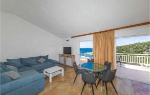 a living room with a blue couch and a glass table at Gorgeous Home In Vinisce With Jacuzzi in Vinišće