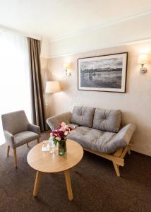 ein Wohnzimmer mit einem Sofa und einem Tisch in der Unterkunft Nota Bene Hotel & Restaurant in Lwiw