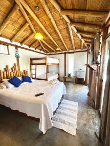 ein Schlafzimmer mit einem großen Bett in einem Zimmer mit Holzdecken in der Unterkunft Casa Lodge (primera fila) in Vichayito