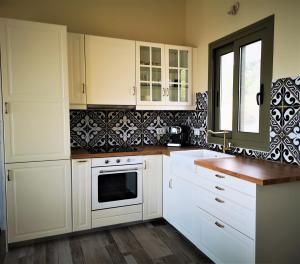 una cucina bianca con armadi bianchi e una finestra di ReLux Villa a Cefalonia
