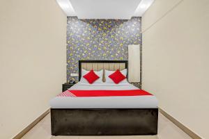 a bedroom with a large bed with red pillows at OYO Flagship Hotel Smbha Palace in Mumbai