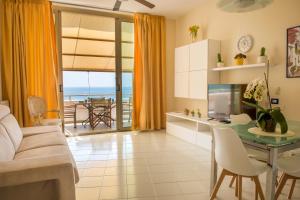 - un salon avec un canapé et une table avec une télévision dans l'établissement Vento Verde Apartments, à Sperlonga