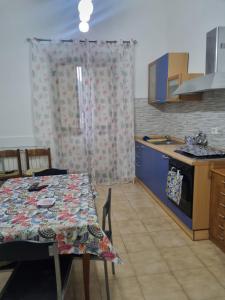 - une cuisine avec une table et une nappe dans l'établissement Castel house, à Fiumefreddo di Sicilia
