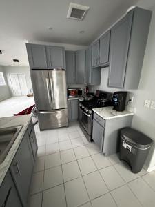 a kitchen with a stainless steel refrigerator and cabinets at Beach House in heart of NYC in Arverne