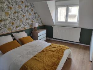 ein Schlafzimmer mit einem großen Bett und einem Fenster in der Unterkunft Maison cosy au cœur de la vieille ville in Boulogne-sur-Mer