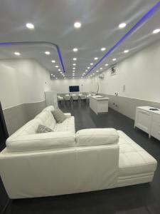 un divano bianco in una stanza con scrivanie e tavoli di Lux House a Napoli