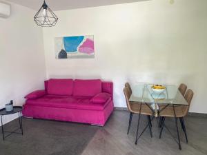 a living room with a pink couch and a table at Tijara Apartment in Rijeka