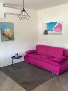 een roze bank in een woonkamer met een tafel bij Tijara Apartment in Rijeka