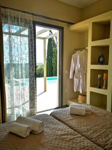 een slaapkamer met een bed en een grote glazen schuifdeur bij ReLux Villa in Kefallonia