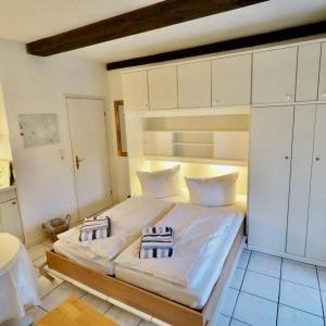 1 dormitorio con 1 cama blanca grande y armarios blancos en Duenenrose, en Tinnum