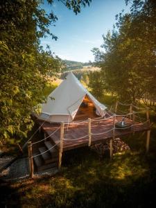 Drábsko的住宿－Yatu Ecological Glamping，田野木甲板上的白色帐篷