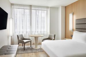 a hotel room with a bed and a table and chairs at AC Hotel by Marriott Houston Downtown in Houston