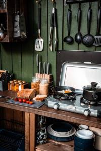 a kitchen with a stove with food and utensils at Yatu Ecological Glamping in Drábsko