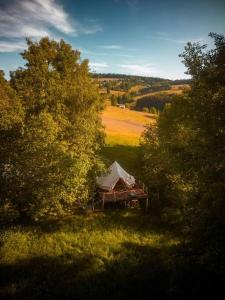 a tent in the middle of a field with trees at Yatu Ecological Glamping in Drábsko