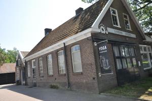 un vieux bâtiment en brique avec un panneau. dans l'établissement Bed & Breakfast de Hoefstal, à Noord-Sleen