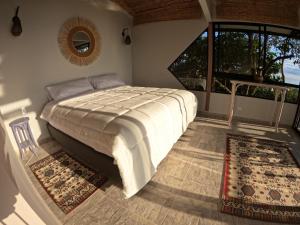 a bedroom with a bed and a large window at Eco Lodge SOL- SUE in La Mesa