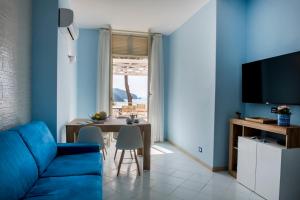 a blue living room with a blue couch and a table at Vento Verde Apartments in Sperlonga
