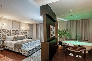 a bedroom with a bed and a bath tub at Brut by Slaviero Hotéis in Balneário Camboriú +123 photos