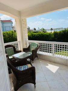 a porch with chairs and a table with a view of the ocean at Marina in El Alamein