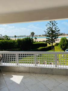 a balcony with a white fence and a view of the beach at Marina in El Alamein