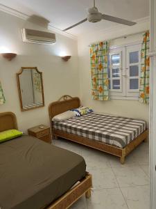 a bedroom with two beds and a mirror and a window at Marina in El Alamein