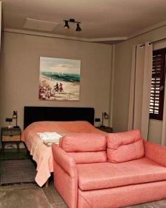 sypialnia z łóżkiem, kanapą i obrazem w obiekcie Kuća Aurora w Rovinj