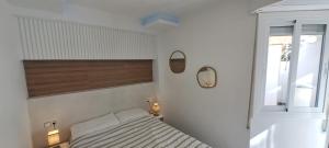 Un dormitorio pequeño con una cama y una ventana. en Port 1, en Tarragona