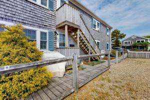 a house with a wooden porch and a wooden fence at Bayside on Commercial in Provincetown