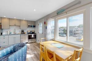 a kitchen and dining room with a table and a blue couch at Bayside on Commercial in Provincetown