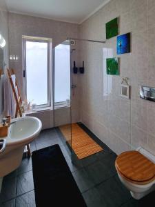 a bathroom with a shower and a toilet and a sink at Palmtree 37 Al in Praia da Vitória