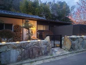 una casa con una pared de piedra y una valla en Natural open-air hot spring Chizu - Vacation STAY 16412v en Takamatsu