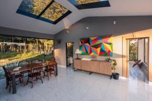 a dining room with a table and chairs and a painting at Reserva Cabanas in Balsa Nova