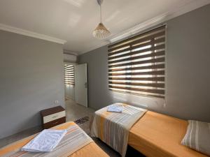 a bedroom with two beds and a window with blinds at Villa De North in Trabzon