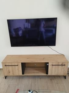 uma televisão de ecrã plano em cima de um centro de entretenimento em madeira em appartement 4 couchages renovés entièrement em Cavaillon