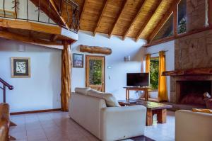 - un salon avec un canapé et une cheminée dans l'établissement BOG Casa Glorieta - casa 4 cuartos, à Villa La Angostura