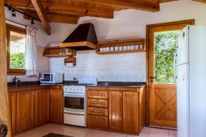 La cuisine est équipée de placards en bois et d'un four avec plaques de cuisson. dans l'établissement BOG Casa Glorieta - casa 4 cuartos, à Villa La Angostura