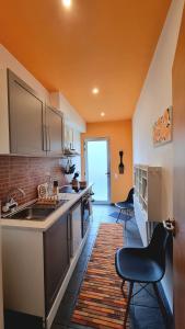 a kitchen with a sink and two chairs in a room at Palmtree 37 Al in Praia da Vitória