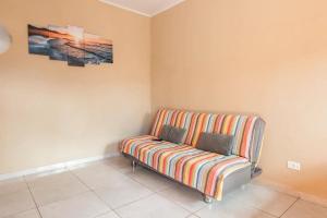 un sofá a rayas en una esquina de una habitación en Chalés Ilhabela Esmeralda, en Ilhabela