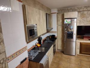 a kitchen with a sink and a refrigerator at Ca Serrulleta in Ascó