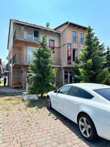 a white car parked in front of a building at Velvet Motel in Hegyeshalom