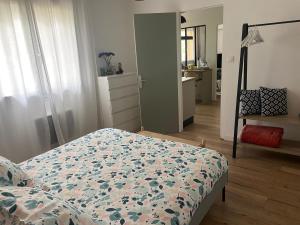coconing et chaleureux T2 في روشيفور دو جار: غرفة نوم مع سرير مع لحاف من الزهور