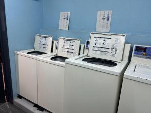three washing machines are lined up against a wall at Himawari-Kan Standard room Male only - Vacation STAY 74345v in Yokohama
