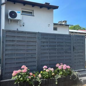 a fence with flowers in front of a house at Abrahama Green House in Władysławowo