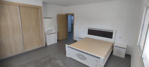 une chambre avec un lit et des armoires dans l'établissement Logement familial 2, à Selouane
