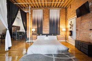 a bedroom with a large bed in a brick wall at Downtown Detroit Loft - Fully equipped & Absolutely Gorgeous theme in Detroit