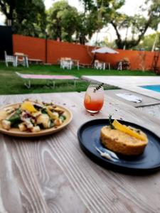 una mesa con un plato de comida y un sándwich y una bebida en Casa Aqua hotel boutique en Mendoza