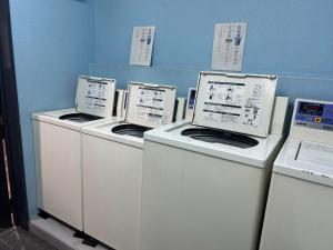 three washing machines are lined up against a wall at Himawari-Kan Standard room Female only - Vacation STAY 74387v in Yokohama