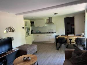 un soggiorno con divano e una cucina con tavolo di Restful Holiday Home with a Private Terrace and hottub a Veendam